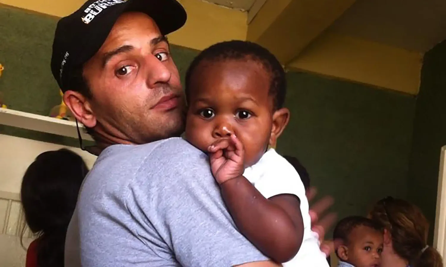 Izidor in Haiti holding small child in his arms